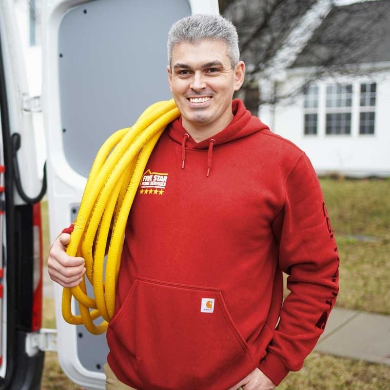 Technician holding yellow gas line by service van