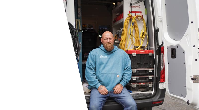 Technician seated at back of equipped service van